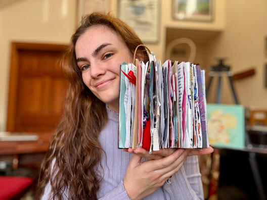 Completed Art Journal #1 (2025) The artist holds a thick art journal.